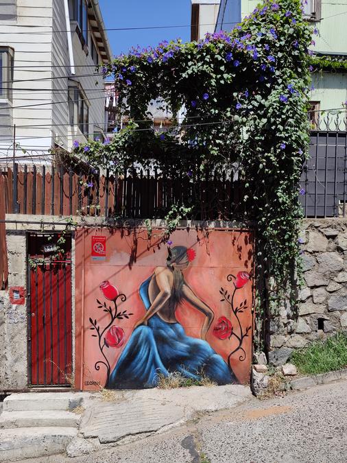 Street art of a woman in blue dress dancing.