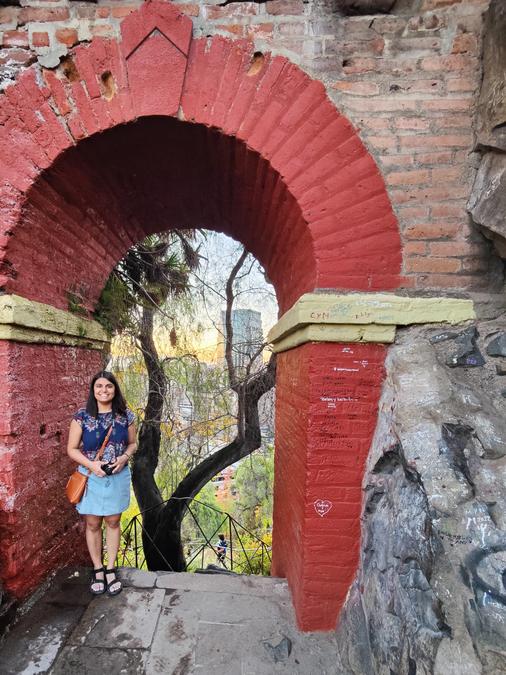 Aishwarya framed in an arch underneath the peak viewing platform on Cerro Santa Lucía.